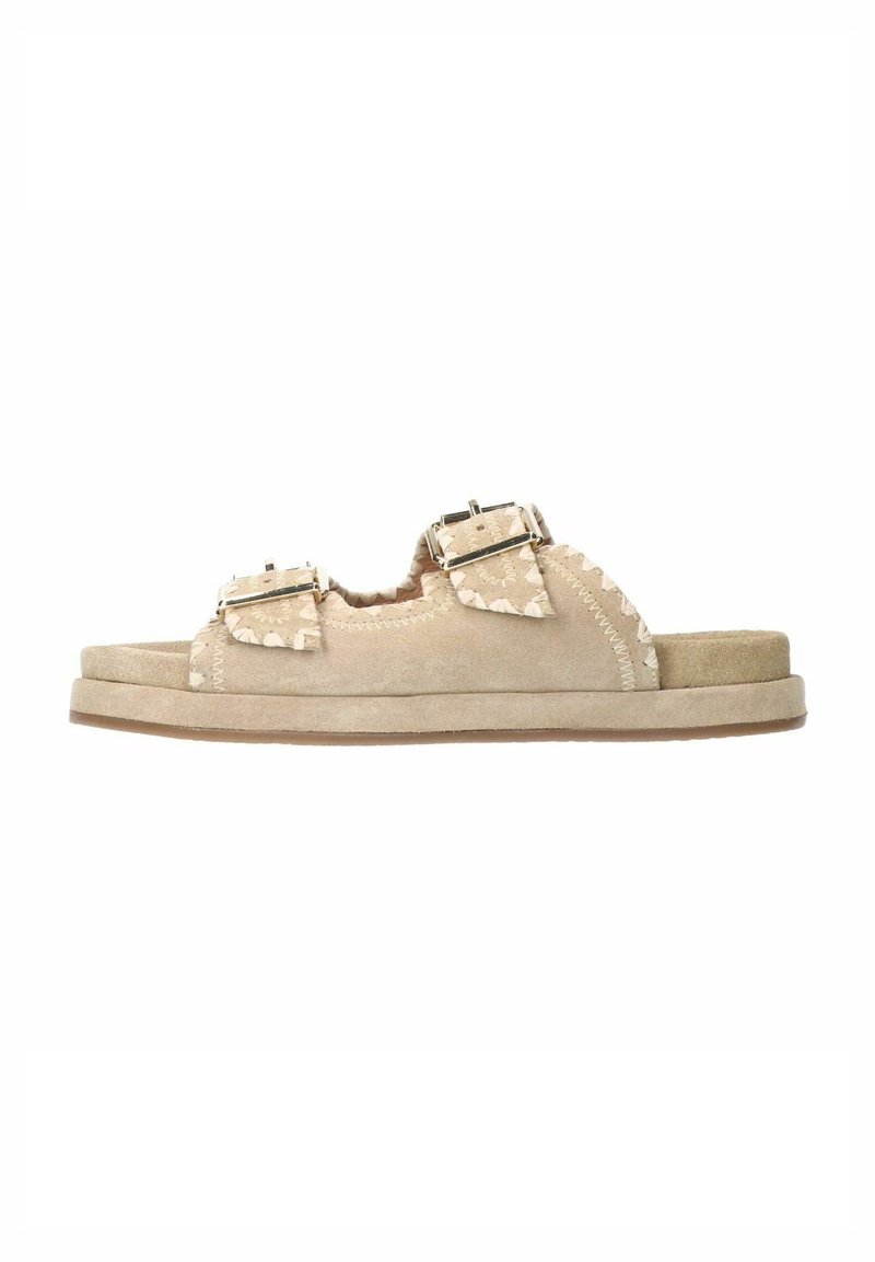 Beige suède instapsandalen met dubbele verstelbare gespen, gegolfde randen en een gewatteerd tussenzool met een rubberen buitenzool.