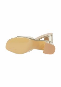 Scarpa con tacco alto slingback in oro, caratterizzata da una finitura metallica liscia, punta rotonda e una suola in gomma beige testurizzata per una migliore aderenza.