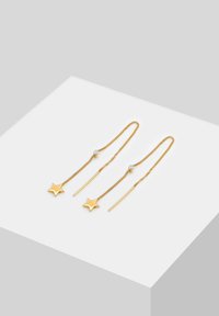Pendientes en forma de estrella dorada con un diseño de cadena, con un acento de cristal redondo; acabado elegante, hilos alargados y enlaces texturizados.