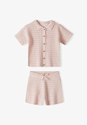 Svijetloružičasta kratka košulja s gumbima od pletenog materijala s kratkim rukavima i odgovarajući šorc s vezicama i nježnim uzorkom izvezenih rupica.