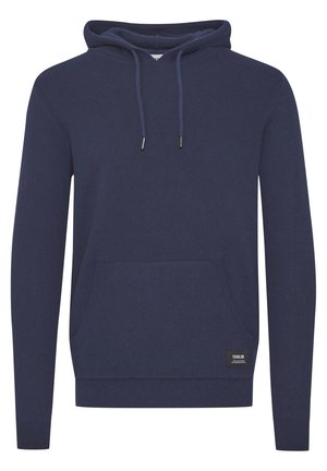 Tamna modra kapuca iz mehke tkanine, opremljena z kengurujskim žepom, rebrastimi manšetami, nastavljivimi vrvicami in majhno oznako blagovne znamke na robu.