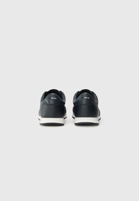 Schwarze Leder-Sneaker mit glatter Oberfläche, weißer Gummisohle und minimalistischem Design. Verfügt über gestickte Akzente an der Ferse.