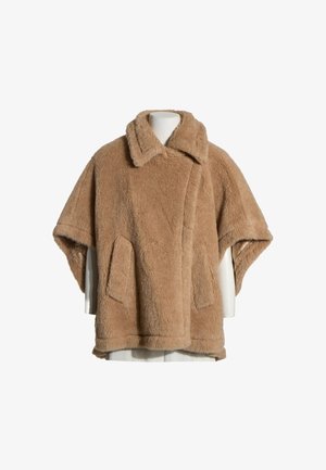 Abrigo teddy marrón claro de manga corta con cuello ancho y bolsillos delanteros sobre un torso de maniquí blanco con fondo blanco.
