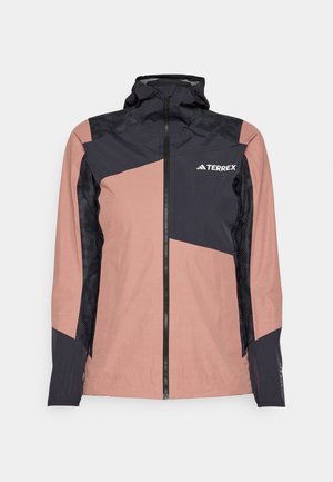 Ružová a čierna nepremokavá bunda s vysokým golierom, zipsom vpredu a geometrickým vzorom. Obsahuje textúrované čierne panely a logo značky.