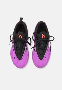 Een paar paarse en zwarte sportschoenen met zwarte veters en een rood logo op de tongen, van bovenaf bekeken op een witte achtergrond.