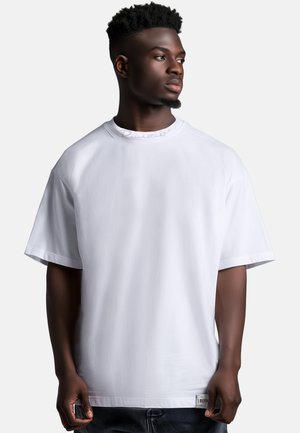 White short-sleeve t-shirt made from smooth fabric, featuring a round neckline and a subtle branded tag at the hem.