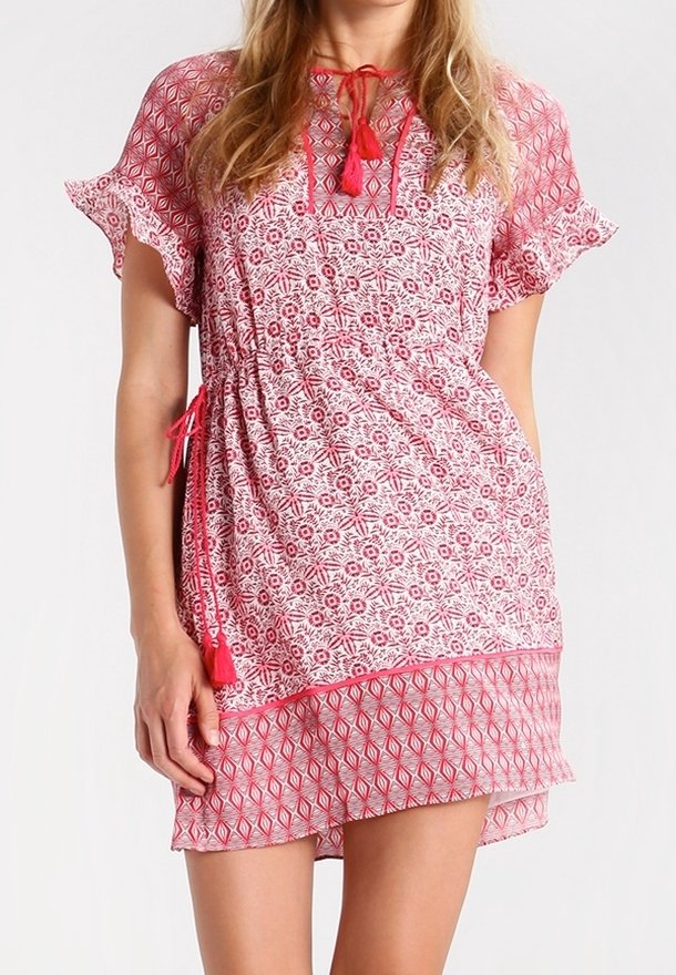 Krátké červenobílé šaty s květinovými a geometrickými vzory, volánkovými rukávy, stahovacími šňůrkami v pase a třásňovými akcenty. Poloprůhledná látka.