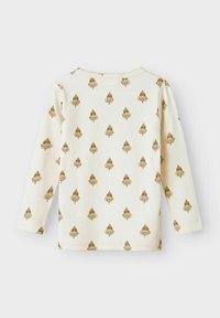 Långärmad topp i krämfärgad ribbad tyg, prydd med ett återkommande mönster av gyllene träd. Rund halsringning och rak nederkant med uppvikta ärmar.