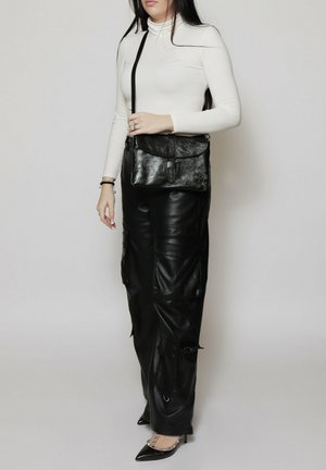 Schwarze Leder-Umhängetasche mit Klappenverschluss und verstellbarem Tragegurt, vor einem neutralen Hintergrund. Die Tasche hat eine strukturierte Oberfläche.