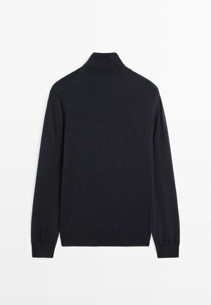 Pull en laine noire à manches longues et col roulé avec des bords côtelés, posé à plat montrant le dos.