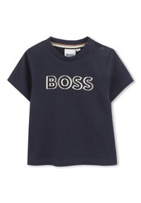 Navy blue short-sleeve T-shirt made of cotton, featuring a large "BOSS" logo in cream. Includes snap fasteners on the shoulder.