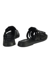 Sandales noires avec un design à lanières et une semelle plate. Fabriquées à partir d'un matériau lisse, elles possèdent un bout arrondi et un dos ouvert.