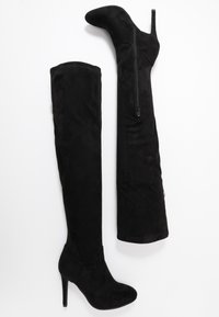 Stivali neri sopra il ginocchio in morbido camoscio. Presentano una punta affilata, un alto tacco a stiletto e un dettaglio con cerniera sul lato. Texture liscia in tutto il prodotto.