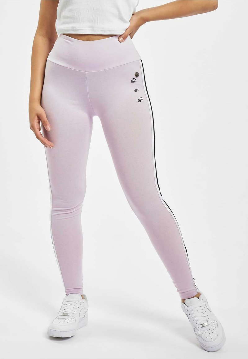 Világos rózsaszín leggings, magas derékkal, fekete oldalsávokkal és kisebb grafikus kiegészítőkkel, például szivárvánnyal és szemekkel. Sima textúra.