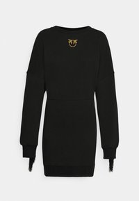 Robe noire à manches longues avec un col rond, ornée d'un petit emblème d'oiseau doré sous le col et de poignets à franges.