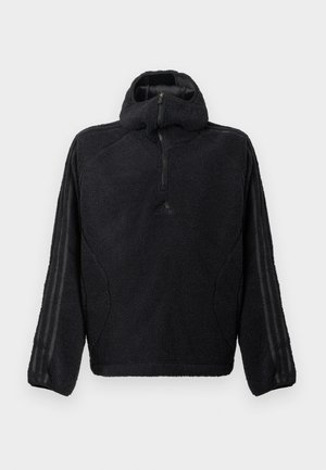 Czarny polarowy sweter z kołnierzem na pół suwak, z teksturowanym wykończeniem i czarnymi paskami na rękawach.