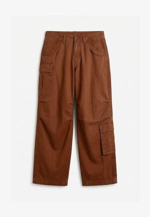 Pantalon cargo marron à jambes droites avec fermeture à bouton, poches latérales à rabat et poches avant en biais, étalé à plat sur une surface blanche.