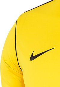 Gelbes Sportshirt mit kurzen Ärmeln, ausgestattet mit einem schwarzen Nike-Logo und dünnen schwarzen Piping entlang der Nähte. Glattes, dehnbares Material.