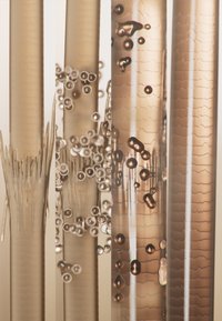 Cztery szklane rurki o różnych średnicach, prezentujące odcienie bursztynu. Widoczne bąbelki i teksturowe wzory podkreślają przezroczystość i złożoność.