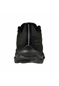 Zapatilla atlética negra con una parte superior de malla texturizada, trasero redondeado y suela lisa. Cuenta con una banda reflectante centrada en la parte posterior.