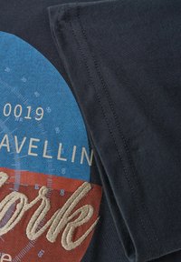 Niebieska koszulka bawełniana w kolorze granatowym z wielokolorową grafiką, na której znajduje się napis "Nowy Jork" wyhaftowany w beżowym kolorze oraz elementy wzoru kompasu. Krótkie rękawy.