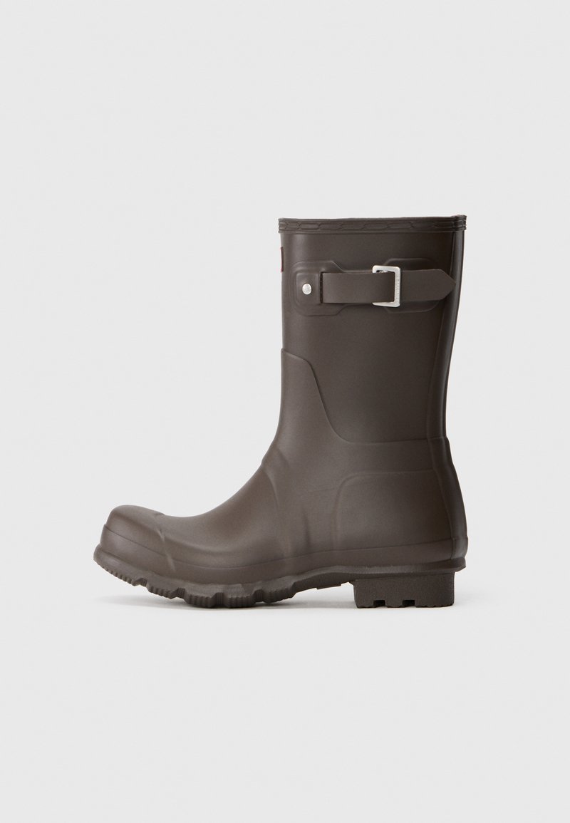 Bota de chuva de borracha castanha com superfície texturizada, design moldado, bico redondo e um detalhe de fivela de metal prateado na lateral.