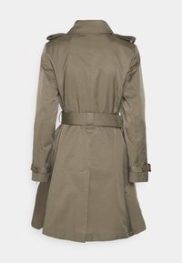 Oliwkowy trench z paskiem w talii, pagonami na ramionach i zapięciem na guziki przy mankietach. Posiada średniej długości krój i gładką teksturę tkaniny.