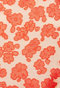 Kevyt kangas, jossa on kirkkaan oranssi kukkakuosi, monimutkaisia kudontayksityiskohtia ja vaihtelevia kukkamuotoja vaalean beige taustan päällä.