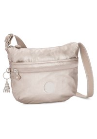 Beige crossbody taske lavet af blødt, shiny stof, med en forreste lynlås lomme, dekorativ nøglekæde og en tekstureret justerbar rem.