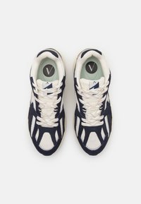 Scarpe sportive navy e bianche con materiali in rete e nubuck, dotate di lacci bianchi, logo prominente e suola in gomma testurizzata.