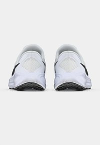 Chaussures de sport blanches avec une tige en mesh texturé, des accents noirs, et une semelle en caoutchouc avec un motif de bande de roulement. Vue arrière montrant un design de talon arrondi.