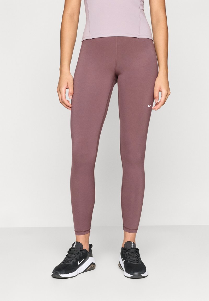 Legginsy Nike w odcieniu stonowanego mauve, elastyczny materiał o gładkiej fakturze. Posiadają dopasowany krój, logo na biodrze oraz szwy wzdłuż nóg.