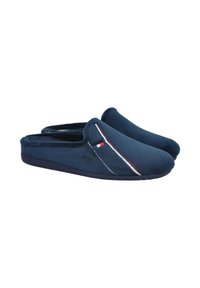 Zapatillas de color azul marino con tela suave y texturizada, con detalles de costuras en blanco y rojo y diseño de punta redonda. Estilo fácil de poner.