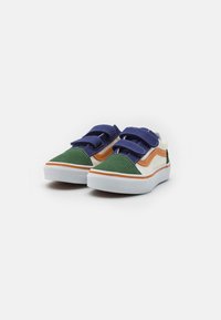 Zapatillas de velcro con punta de lona verde, acentos de ante azul marino y naranja, suela de goma blanca y detalles de costura en contraste.