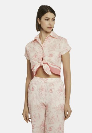 Korte mouwen roze overhemden met een geknoopte voorkant, met een gedetailleerd toilepatroon. Gecombineerd met bijpassende broek, wat een samenhangende look creëert.