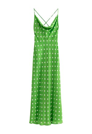 Abito lungo verde senza maniche con pois bianchi, caratterizzato da sottili bretelle incrociate sulle spalle e scollo drappeggiato.