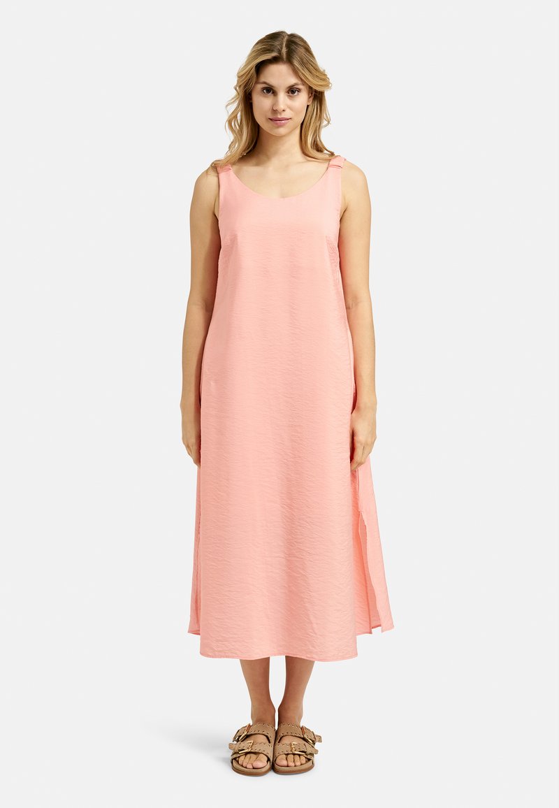 Rosa ärmelloses Kleid mit lockerer Passform, das seitliche Schlitze und strukturierten Stoff aufweist. Getragen mit braunen Riemchensandalen.
