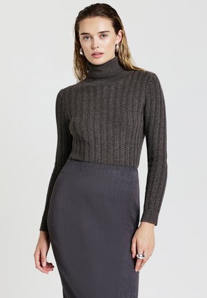 Maglione a collo alto grigio scuro a coste con maniche lunghe, abbinato a una gonna a tubino grigia, caratterizzata da una texture liscia e un design aderente.