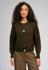 Cardigan tricoté vert foncé avec un motif en chevrons, fermeture à boutons avec des accents métalliques et bords ribbed aux manches et à l'ourlet.