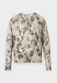 T-shirt à manches longues avec col ras du cou, motif abstrait de feuilles beiges, marron et noires sur un fond clair.