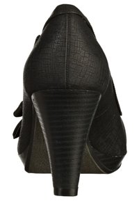 Chaussure noire à talon haut avec une tige texturée, un design effilé et un talon rainuré. Dotée d'un nœud décoratif et d'une doublure intérieure lisse.