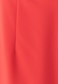 Koraljno crvena tkanina s glatkom, mekanom teksturom. Sadrži detalj nabiranja i suptilan sjaj, pružajući čist, moderan izgled.