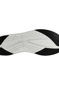 Semelle de chaussure avec un schéma de couleurs noir et blanc. Présente des motifs texturés, des rainures distinctes et une forme courbée pour la flexibilité et l'adhérence.