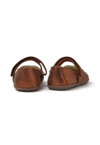 Zapatos de cuero metálico marrón con forma redondeada, correa trasera y superficie texturizada. Suelas planas y diseño minimalista.