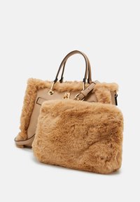 Due borse abbronzate con hardware dorato; una è in pelle liscia con bordo in pelliccia, l'altra è completamente coperta di morbida pelliccia abbronzata.