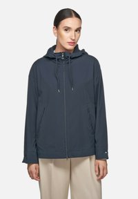 Donkerblauwe lichtgewicht jas met een capuchon, ritssluitingen, verstelbare koordjes en zijzakken. Glad textuur en een casual ontwerp.