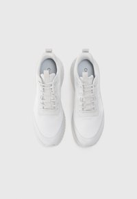 Λευκά αθλητικά παπούτσια με υφασμάτινη επάνω με υφή, στρογγυλή μύτη και παχιά λαστιχένια σόλα. Σχοινιά και λεπτομέρεια με θηλιά στην φτέρνα.