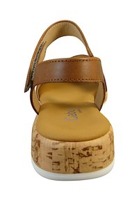 Brown leather adjustable strap sandal with a cork wedge heel, tan insole, and a white rubber outsole, showcasing a smooth texture and clean lines.