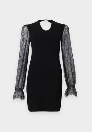 Black dress with a fitted bodice, lace long sleeves, and a keyhole neckline. Flared lace cuffs add texture. Features a metallic clasp at the back.