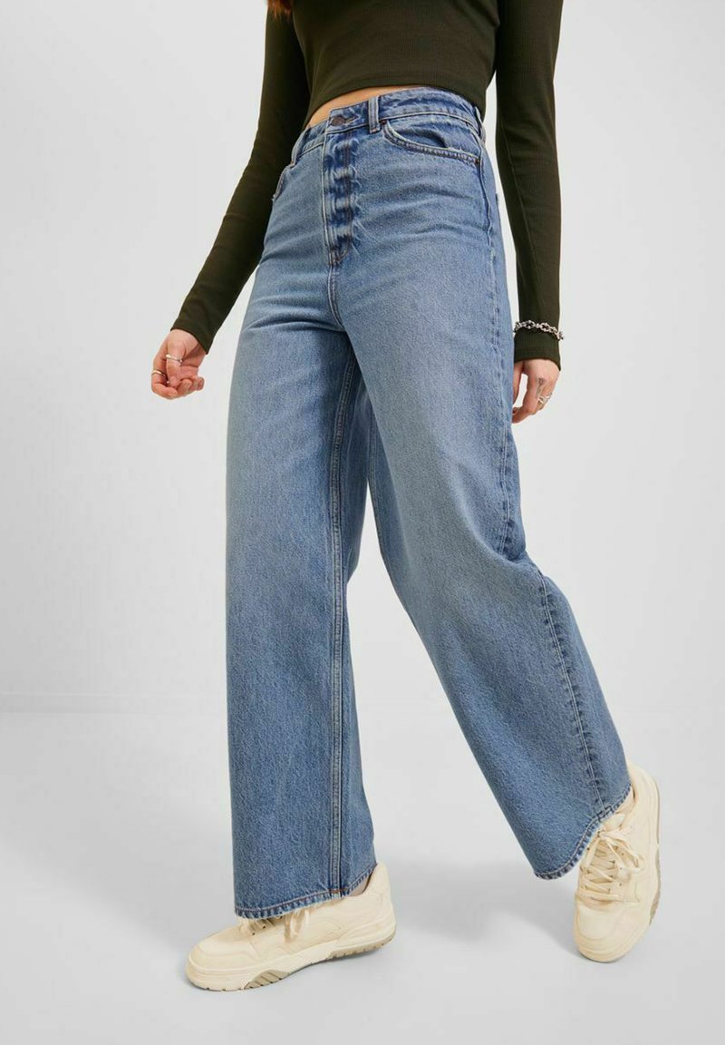 Jeans a gamba larga di un blu chiaro presentano un alto punto vita, chiusura frontale con cinque bottoni, una classica trama di denim e dettagli di cucitura sottili.